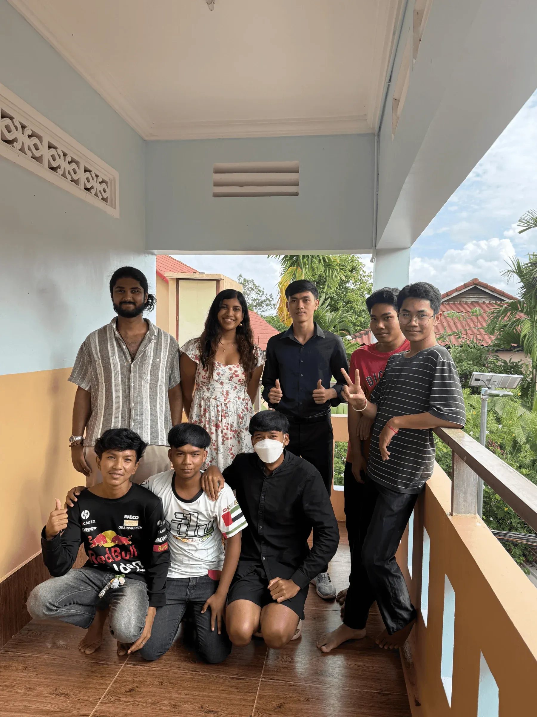 A group of Cambodian students and Matsya team members posing together on a balcony in Siem Reap