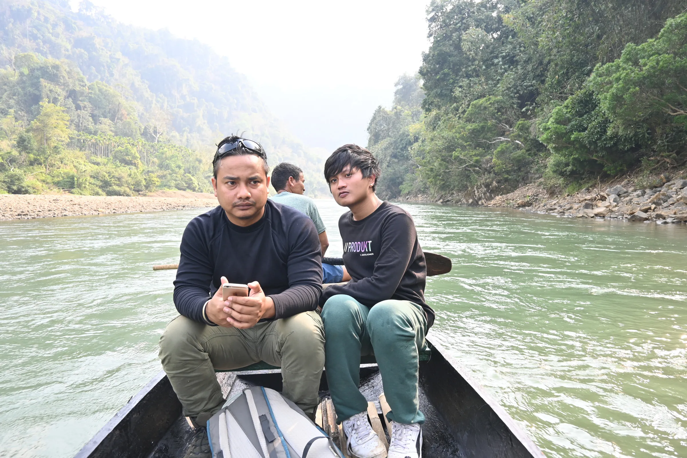 Two members of the field team travelling upriver by boat on a survey